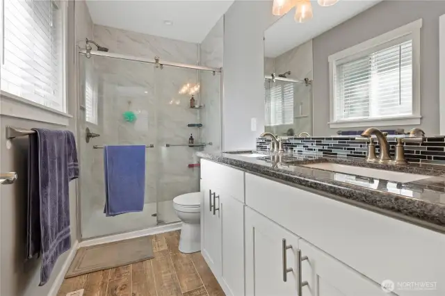 newer primary bath Quartz counters newer vanity two sinks tile floors and a 5 foot walk in shower