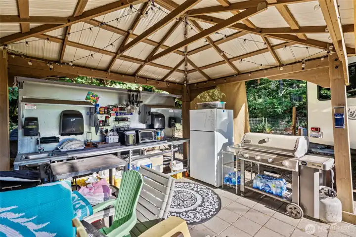 Outdoor Kitchen. Appliances stay. BBQ goes. Power, Water, Sinks, tiled, refrigerator, heated water.