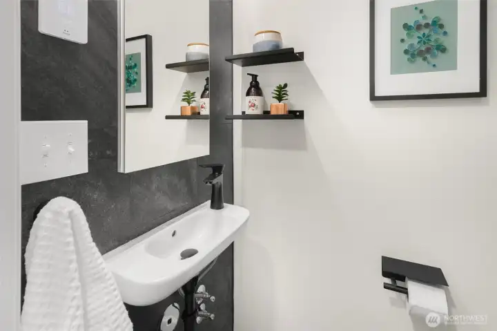 Renovated half bath on main floor features heated floor new cabinetry plus Duravit toilets.