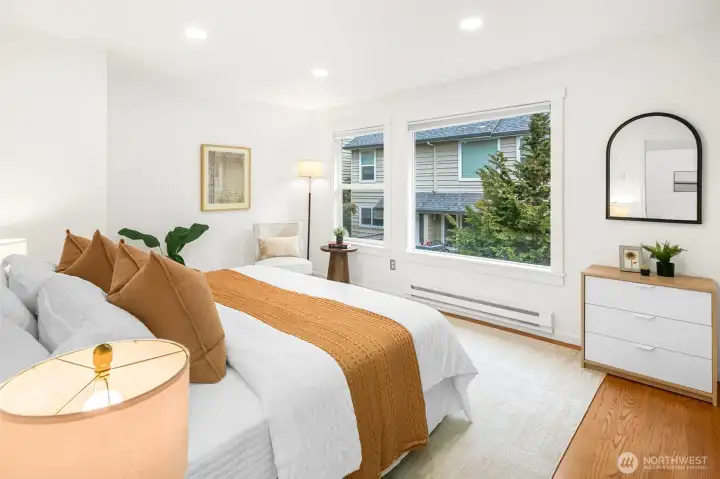 King size primary bedroom with picturesque windows and custom closet shelving.