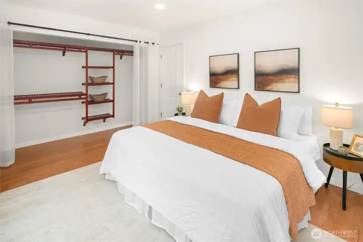 King size primary bedroom with picturesque windows and custom closet shelving.