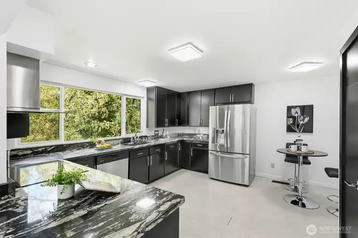 Stunning kitchen freatures striking granite countertops and backsplash with stainless applianaces - including an Induction Stovetop.