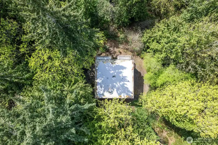 Aerial view of the home surrounded by the private setting. New roof! Up the hill from the Community Boat Launch and waterfront park with easy access to extensive nature trail system.