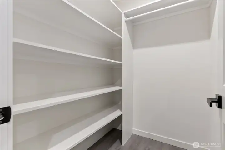 Primary bedroom closet with built-in shelves