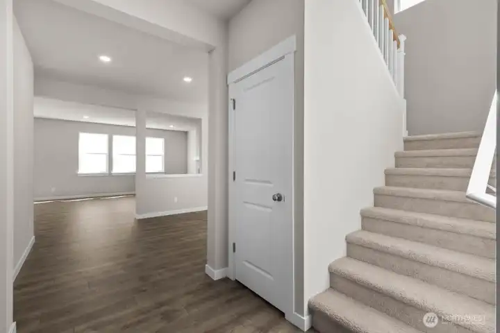 Well lit staircase with picture window and storage under the stairs. Colors and finishes may vary.
