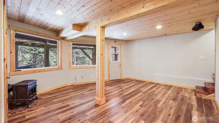 Finished lower level features luxury vinyl plank flooring and access out to under the deck.