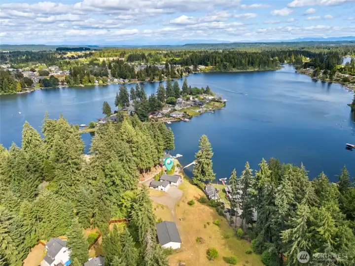 This sweeping aerial gives you a wonderful sense of place, showing the property's 88 feet of Long Lake shoreline, the position of the home along the waterfront and the beautiful setting surrounding it. In the center of the lake sits Holmes Island, one of Long Lake's most recognizable landmarks and a favorite backdrop for boating, paddling and lakeside sunsets. From this perspective, you can appreciate how the home enjoys a spacious setting while still being part of an established waterfront neighborhood. The exterior is finished in durable vinyl siding for years of low-maintenance beauty, and recent improvements include updated exterior lighting and security camera systems that add both convenience and peace of mind. This sweeping aerial gives you a wonderful sense of place, showing the property's 88 feet of Long Lake shoreline, the position of the home along the waterfront and the beautiful setting surrounding it. In the center of the lake sits Holmes Island, one of Long Lake's most recognizable landmarks and a favorite backdrop for boating, paddling and lakeside sunsets. From this perspective, you can appreciate how the home enjoys a spacious setting while still being part of an established waterfront neighborhood. The exterior is finished in durable vinyl siding for years of low-maintenance beauty, and recent improvements include updated exterior lighting and security camera systems that add both convenience and peace of mind.