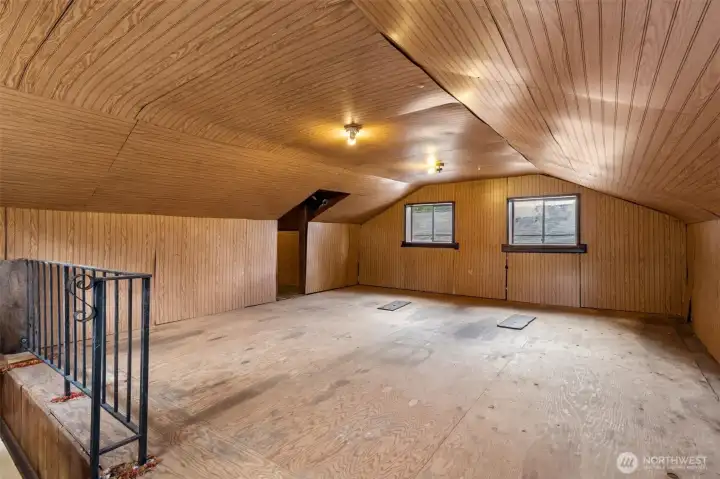 This loft space is exactly the kind of bonus area buyers love because everyone immediately starts imagining something different. Home office? Art studio? Craft room? Collectibles display? The ultimate hideaway for projects that don't belong in the house? Finished with warm wood flooring, paneled walls and ceiling, plus two windows bringing in natural light, the space feels comfortable and surprisingly inviting. The open staircase and black metal loft railing keep the area connected to the garage below while maintaining a spacious feel. Add in the newer composition roof overhead and you've got a detached garage that delivers far more than parking. This loft space is exactly the kind of bonus area buyers love because everyone immediately starts imagining something different. Home office? Art studio? Craft room? Collectibles display? The ultimate hideaway for projects that don't belong in the house? Finished with warm wood flooring, paneled walls and ceiling, plus two windows bringing in natural light, the space feels comfortable and surprisingly inviting. The open staircase and black metal loft railing keep the area connected to the garage below while maintaining a spacious feel. Add in the newer composition roof overhead and you've got a detached garage that delivers far more than parking.