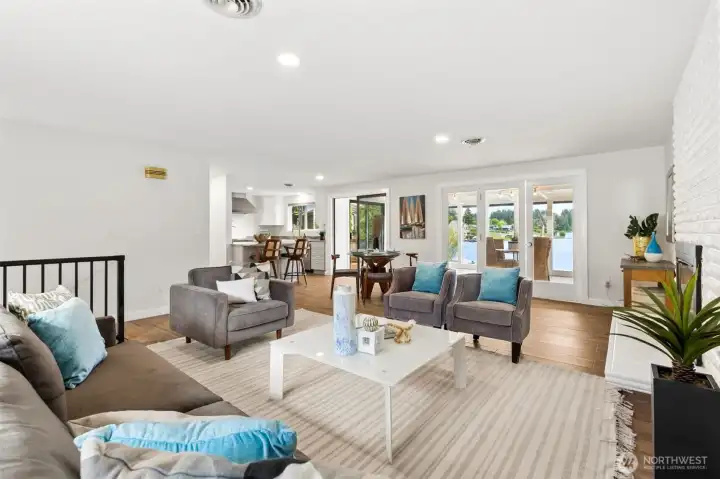 From this angle, you can appreciate how beautifully the living room, dining area and kitchen all work together while still feeling like distinct spaces. The sunroom and lake views beyond become a natural focal point, drawing light deep into the home and creating that easy waterfront lifestyle vibe buyers are hoping to find. The staircase leading to the lower level is positioned just enough off to the side that it doesn't interrupt the flow, and every space feels connected without becoming one giant room. Built in 1974 and offering 2,392 square feet, this home has been refreshed in all the right ways, blending modern updates with the warmth, character and solid craftsmanship that made people fall in love with homes from this era to begin with. From this angle, you can appreciate how beautifully the living room, dining area and kitchen all work together while still feeling like distinct spaces. The sunroom and lake views beyond become a natural focal point, drawing light deep into the home and creating that easy waterfront lifestyle vibe buyers are hoping to find. The staircase leading to the lower level is positioned just enough off to the side that it doesn't interrupt the flow, and every space feels connected without becoming one giant room. Built in 1974 and offering 2,392 square feet, this home has been refreshed in all the right ways, blending modern updates with the warmth, character and solid craftsmanship that made people fall in love with homes from this era to begin with.
