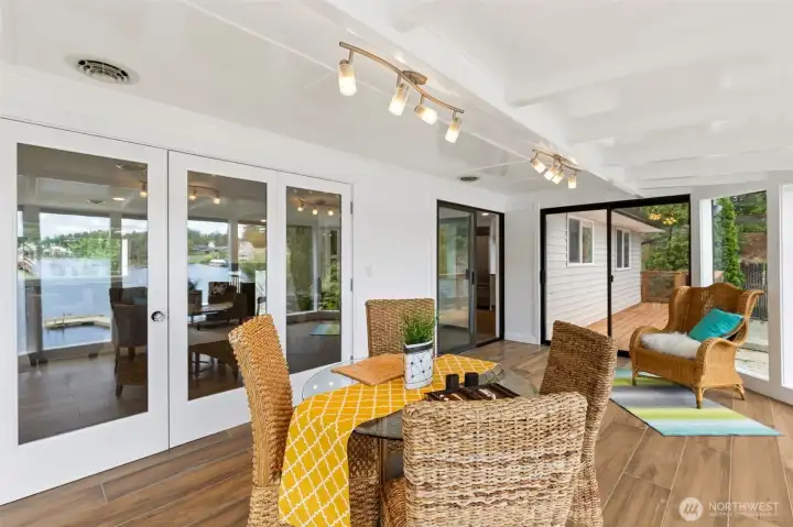 Surrounded by a dramatic wall of floor-to-ceiling glass, this incredible sunroom delivers the kind of lake views that stop people mid-sentence. The perspective from here feels almost suspended above the water, with sweeping views extending down the length of Long Lake and a front-row seat to spectacular eastern sunrises. Rich luxury vinyl plank flooring keeps the space beautiful and practical, while the sliding glass door creates an easy connection to the deck outside. Whether it's morning coffee, afternoon reading, evening wine or simply watching the weather roll across the water, this room has a way of making ordinary moments feel a little extraordinary. Fair warning: once you sit down here, you may not get much else done. Surrounded by a dramatic wall of floor-to-ceiling glass, this incredible sunroom delivers the kind of lake views that stop people mid-sentence. The perspective from here feels almost suspended above the water, with sweeping views extending down the length of Long Lake and a front-row seat to spectacular eastern sunrises. Rich luxury vinyl plank flooring keeps the space beautiful and practical, while the sliding glass door creates an easy connection to the deck outside. Whether it's morning coffee, afternoon reading, evening wine or simply watching the weather roll across the water, this room has a way of making ordinary moments feel a little extraordinary. Fair warning: once you sit down here, you may not get much else done.