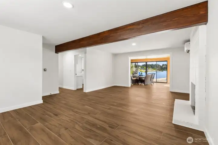 The lower level doesn't feel tucked away at all thanks to bright finishes, thoughtful updates and those gorgeous water views waiting just beyond. This spacious family room pairs a striking exposed wood beam with a classic floor-to-ceiling brick fireplace that has been refreshed in a clean white finish, preserving the home's original character while giving it a lighter, more contemporary feel. A dedicated mini-split adds energy-efficient heating and cooling, making the space comfortable no matter the season. From here, the floorplan naturally flows toward additional bedrooms and living areas, while the lake remains the star of the show. The lower level doesn't feel tucked away at all thanks to bright finishes, thoughtful updates and those gorgeous water views waiting just beyond. This spacious family room pairs a striking exposed wood beam with a classic floor-to-ceiling brick fireplace that has been refreshed in a clean white finish, preserving the home's original character while giving it a lighter, more contemporary feel. A dedicated mini-split adds energy-efficient heating and cooling, making the space comfortable no matter the season. From here, the floorplan naturally flows toward additional bedrooms and living areas, while the lake remains the star of the show.