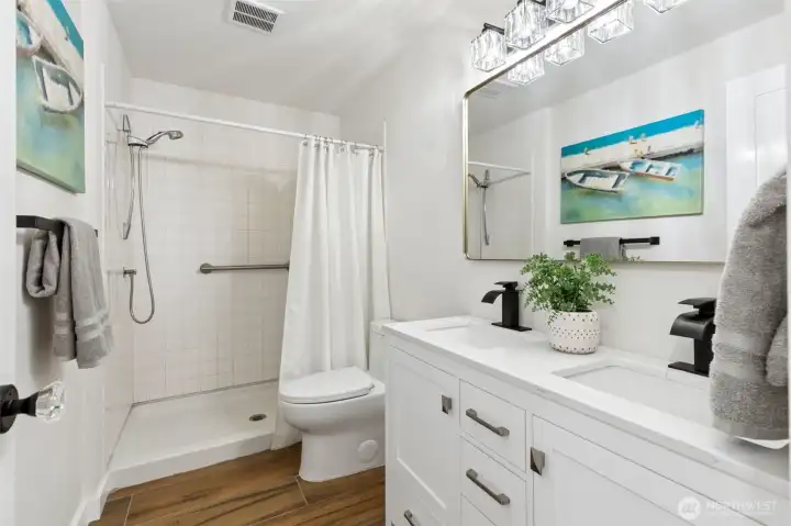 A beautiful double vanity with dual sinks offers plenty of room for busy mornings, while the brand-new fixtures and finishes give the room a clean, contemporary feel. The walk-in shower features attractive tile surrounds that add texture and durability, and the new toilet, lighting and updated finishes mean there's nothing left to do but enjoy it. Waterproof luxury vinyl plank flooring continues the cohesive design story found throughout the home, making this bathroom both beautiful and practical. A beautiful double vanity with dual sinks offers plenty of room for busy mornings, while the brand-new fixtures and finishes give the room a clean, contemporary feel. The walk-in shower features attractive tile surrounds that add texture and durability, and the new toilet, lighting and updated finishes mean there's nothing left to do but enjoy it. Waterproof luxury vinyl plank flooring continues the cohesive design story found throughout the home, making this bathroom both beautiful and practical.