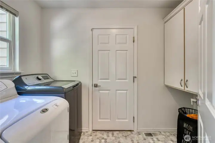 Laundry room is a functional space with new vinyl and cabinets for storage. Laundry room is a functional space with new vinyl and cabinets for storage.