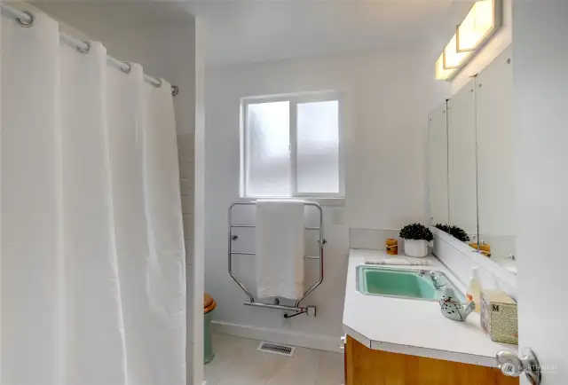 Primary 3/4 Bath . YES--a towel warmer on the wall—some retro color going on w/tub, sink & toilet.