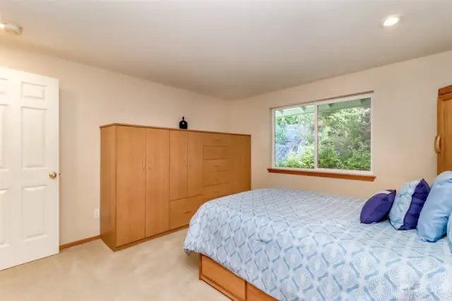 Spacious private primary suite, built-in bedroom set stays, lush greenery of East garden