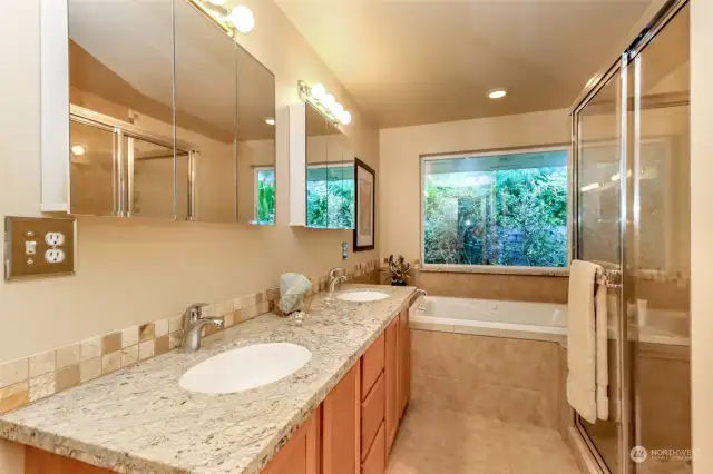 5-piece primary bathroom suite, soaking jetted tub, with view of the luscious landscaping of East garden