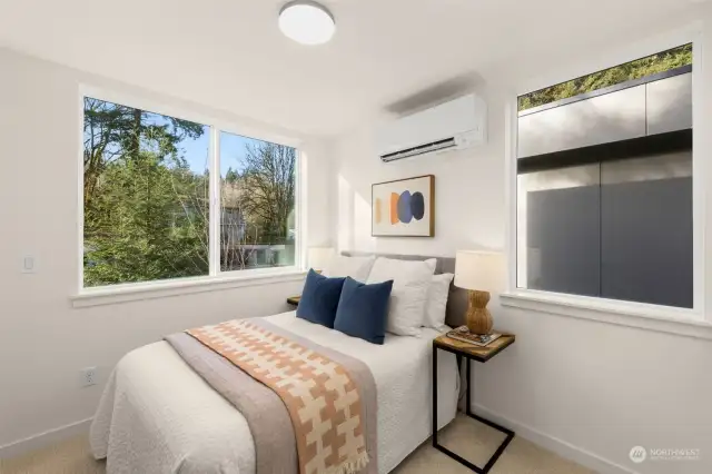 This secondary bedroom is full of charm, with large windows that flood the space with natural light. The stylish decor enhances the cozy, inviting atmosphere, making it the perfect space for guests or a peaceful personal retreat.