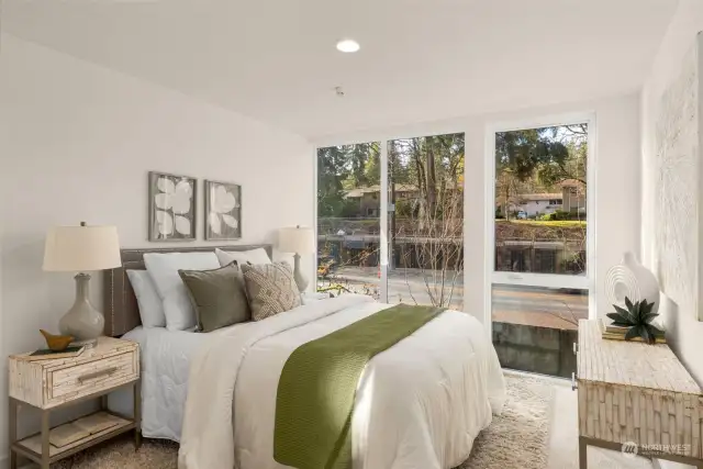 Wake up to peaceful views in this beautifully designed bedroom. Featuring floor-to-ceiling windows and soothing neutral tones, it’s a space that radiates relaxation and warmth.