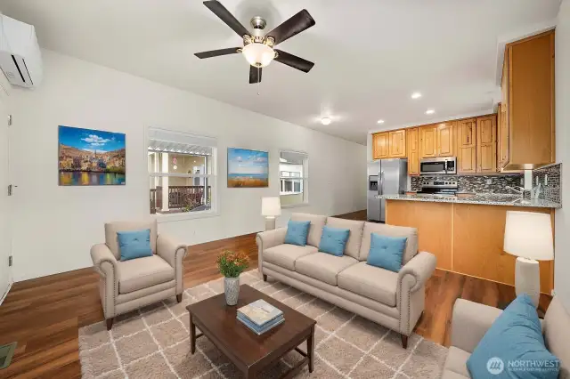 Living Room: Bright, open-concept living area with large windows and wood-style flooring.