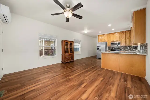 Living Room: Bright, open-concept living area with large windows and wood-style flooring.