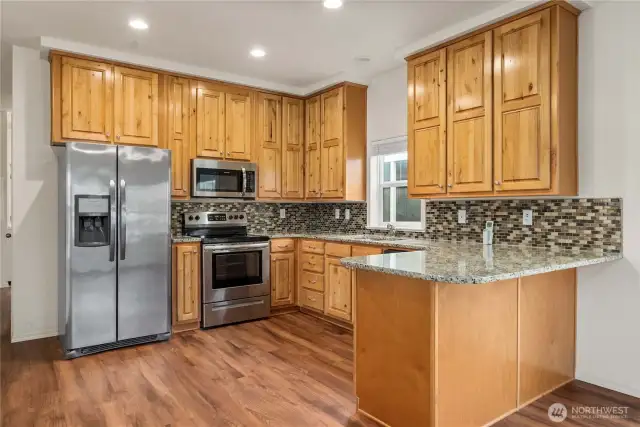 Kitchen: Modern kitchen with stainless steel appliances, granite countertops, and ample cabinetry.