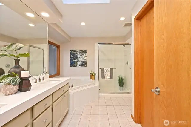 the 5 piece primary bathroom features a skylight,