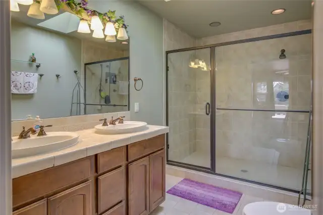 Primary suite has a dual vanity and large, tiled, step in shower.
