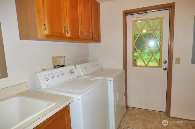 Laundry room with cabinets, sink,washer and dryer (included). Door leads to covered deck.