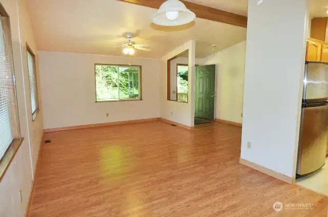 Bright living room with vaulted ceiling and fan.