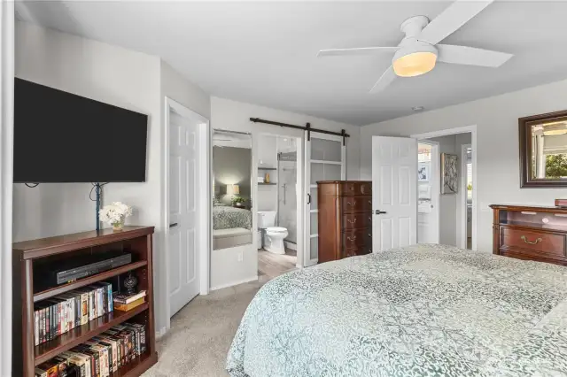 Primary bedroom with walk-in closet and barn door to primary bathroom.