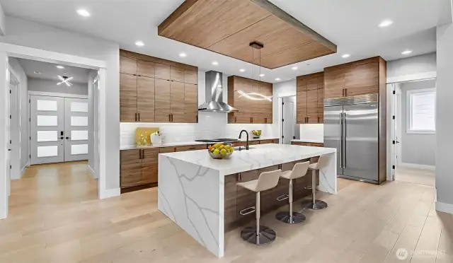 Enviable gourmet kitchen boasts 48" Subzero Refrigerator, Wolf Double-Oven, 6-Burner & Griddle Range, 48" Zephyr Pro Hood, Cove Dishwasher, Sharp Microwave Drawer, and anchored by an oversized waterfall island. Virtually staged