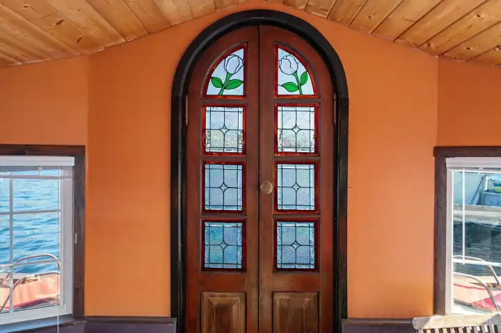 Through the living room, arrive at a beautifully designed set of stained glass double doors that lead out onto the back deck.