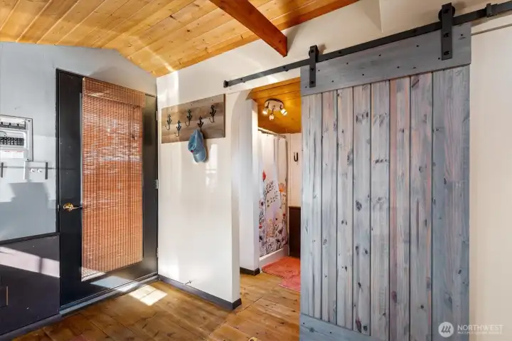 Charming details, like a barn door leading to the bathroom, add rich detail to the interior of the houseboat.