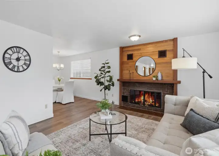 Expansive windows and a cozy wood-burning fireplace create an inviting space to gather or unwind.