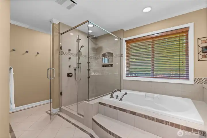 This bathroom has more! Frameless glass enclosed shower with custom tile work and niche shelf.
