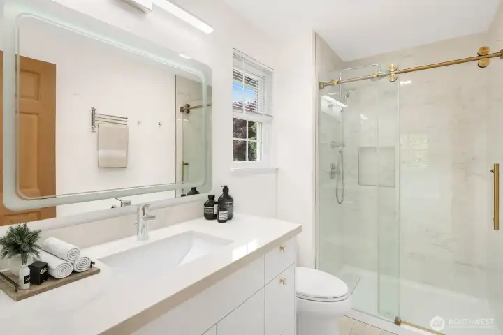 Contemporary Primary Bath Features Sleek Cabinets, Slab Quartz Counters with Undermount Sink, Rain Shower plus Body Wand, and Frameless By-pass Doors - Virtually Staged