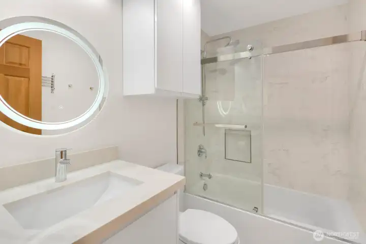 Upper Hall Bath Features Lit Mirror, Contemporary Frameless Shower Door, Modern Cabinets, Rain Shower plus Body Wand, and Slab Quartz Counters with Undermount Sink