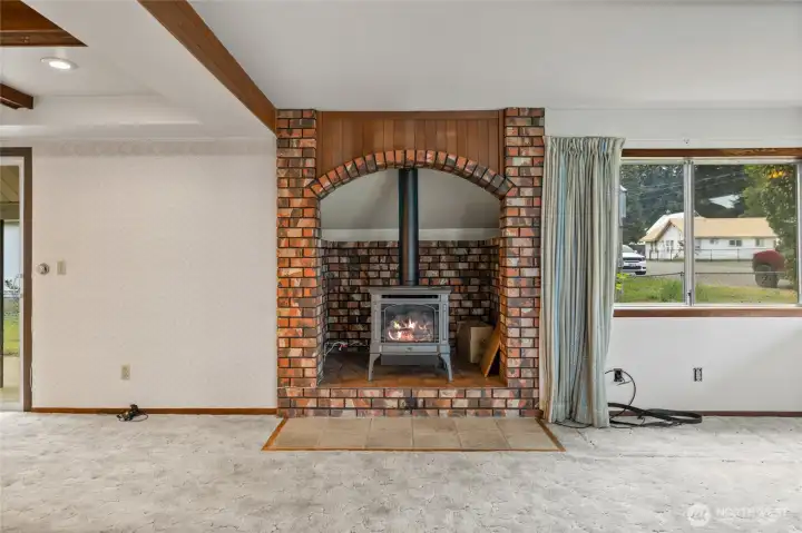 Anchored by warm brick and a cozy fireplace, this living space was built for gathering.