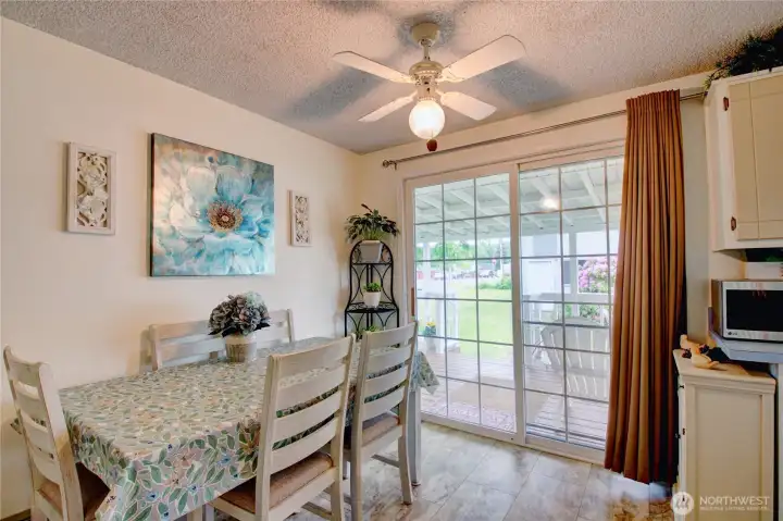 Dining room with ceiling fan and slider to back covered deck. Dining room with ceiling fan and slider to back covered deck.