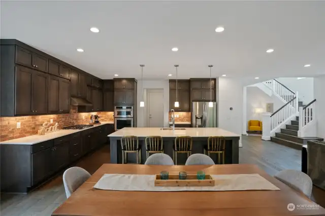 The chef's kitchen is a dream, featuring a generous island, a 5-burner gas cooktop with hood, and two walk-in pantries.