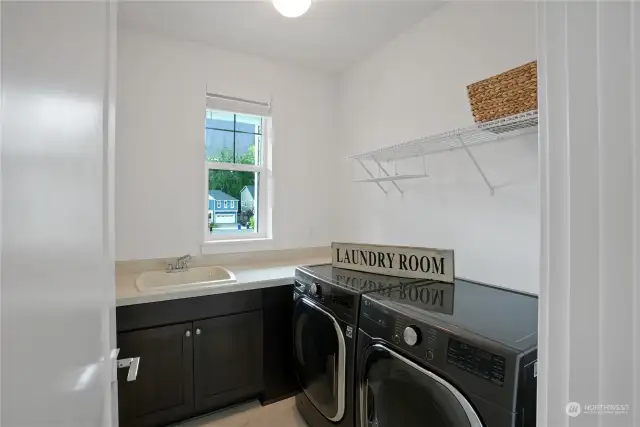 Upper level laundry room with side-by-side washer and dryer, utility sink and plenty of storage.