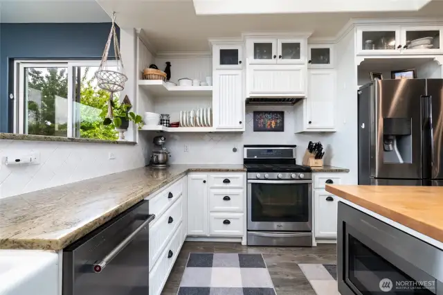 Stainless appliances, farm style cabinets, stone and wood countertops