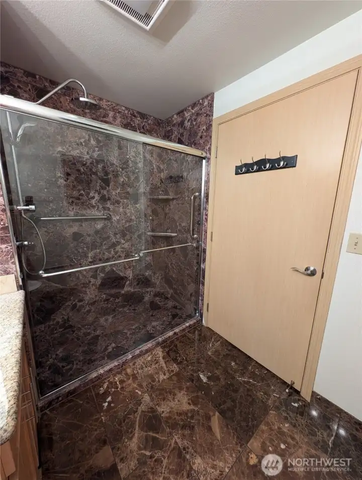 Double shower heads with marble tile.
