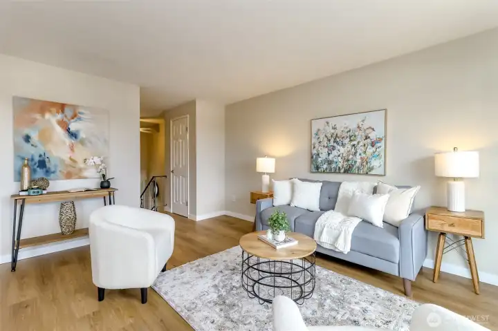 This angle shows the living room facing the stairs down to the entry. The door on the right is the coat closet.