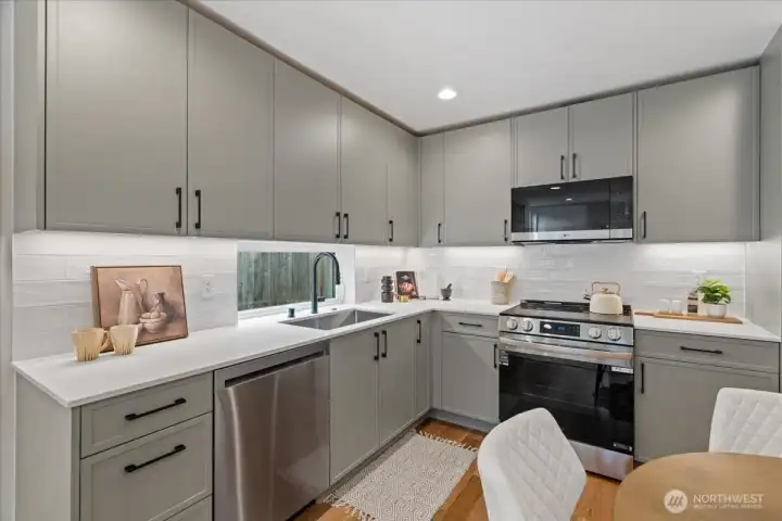 Well-appointed kitchen with custom cabinets, SS appliances, and stylish backsplash. Photo of model unit, 4118. Finishes may vary, buyer to verify.