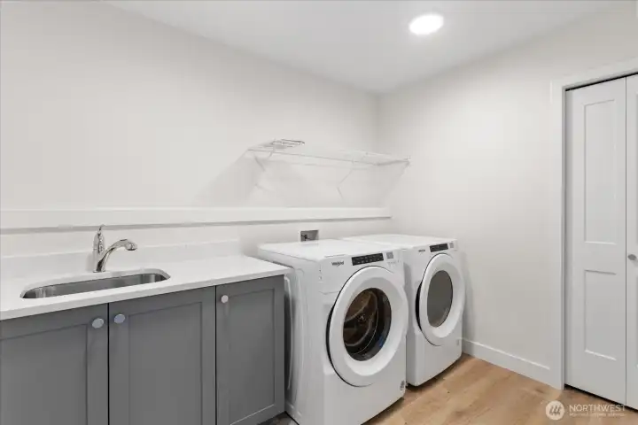 Large laundry room with same quartz counters and linen closet