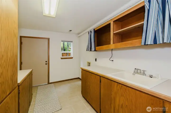Laundry/ Utility room with utility sink .  Laundry shoot collection in tall cabinet