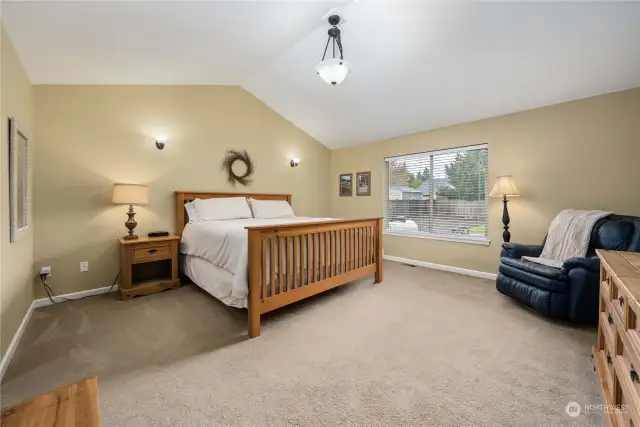 Large primary bedroom with vaulted ceilings. 2 separate closets are in the hallway that leads to bath off primary