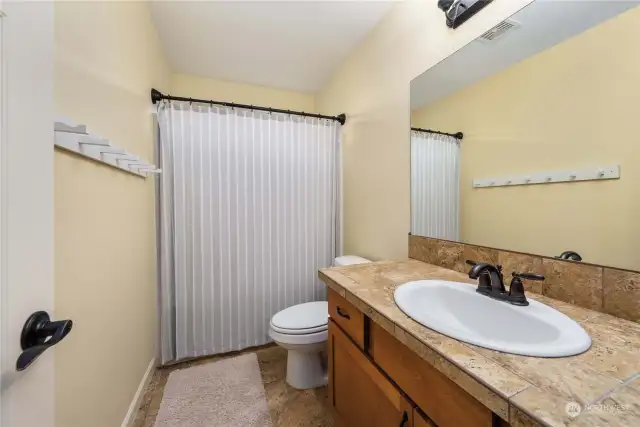 Guest full bath with tile floors and counters