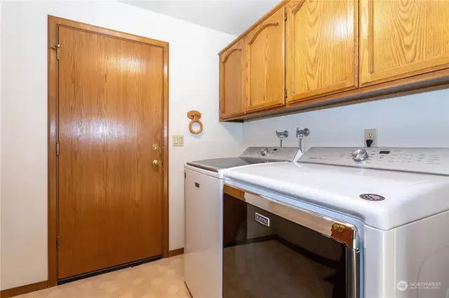 Main floor laundry room with laundry sink and storage.  Door leads to 2 car garage with extra space for workshop